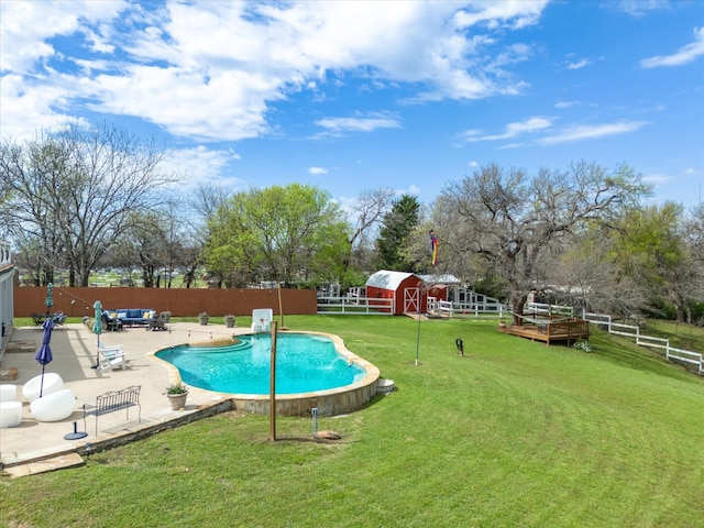 view of swimming pool with an outbuilding, a yard, and a patio area