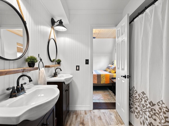 bathroom featuring vanity, crown molding, and wood-type flooring