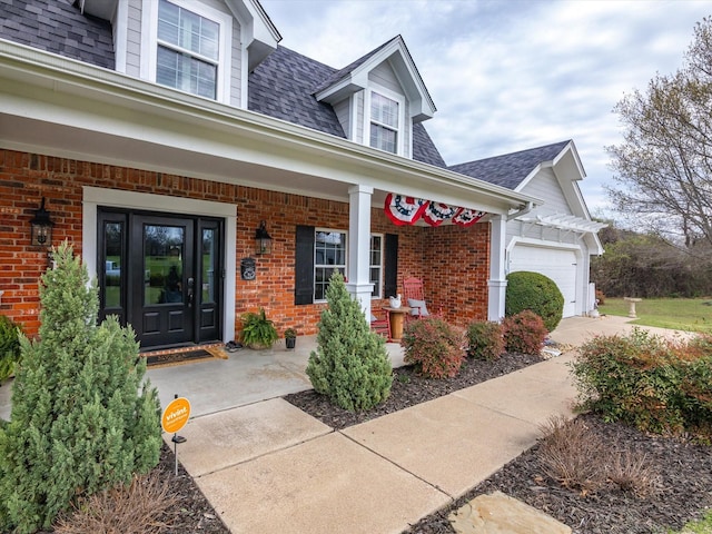 property entrance featuring covered porch and a garage