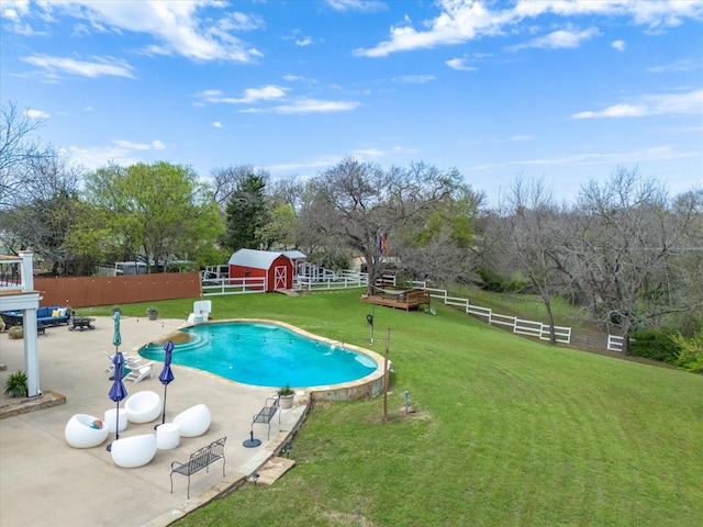 view of pool with a lawn and a shed