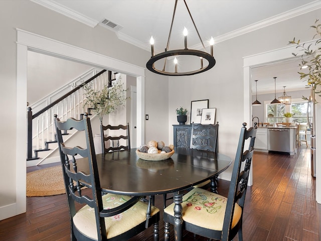 dining room featuring a chandelier, crown molding, and dark hardwood / wood-style floors