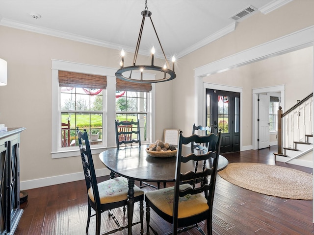 dining room featuring dark hardwood / wood-style flooring, ornamental molding, and an inviting chandelier