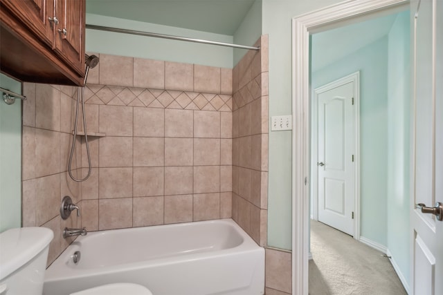 bathroom featuring tiled shower / bath and toilet