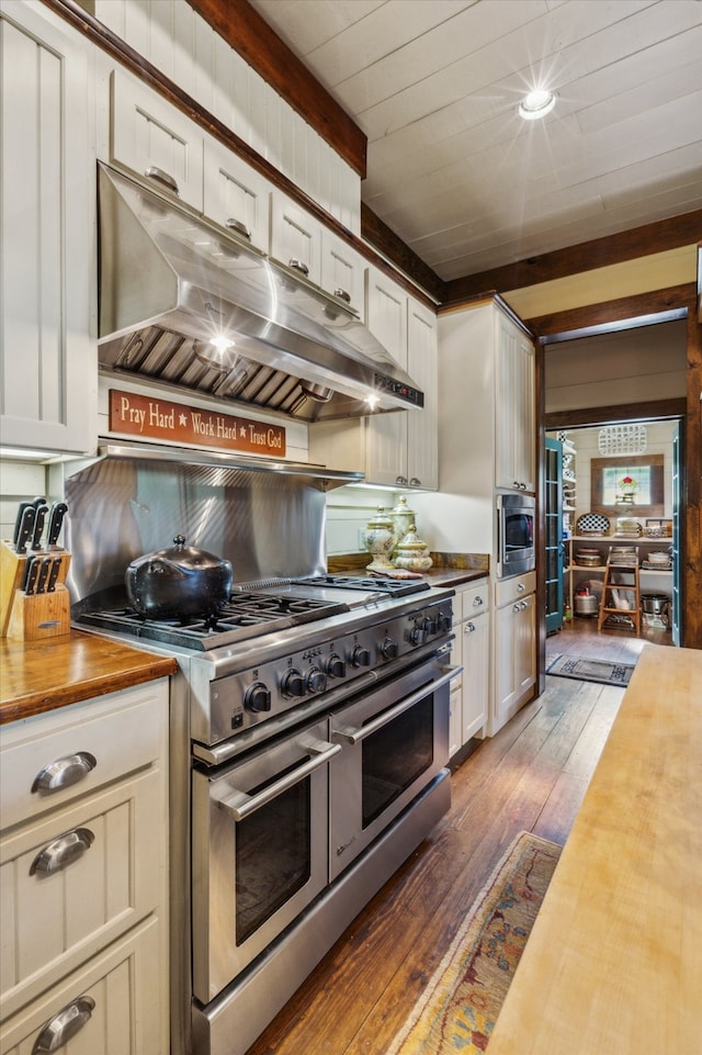 kitchen featuring white cabinetry, stainless steel appliances, butcher block countertops, and wood-type flooring