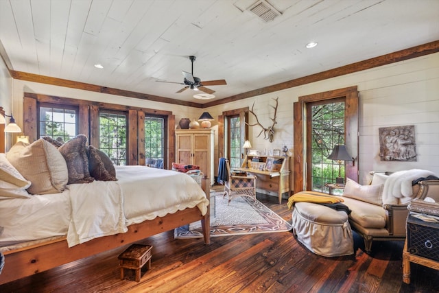 bedroom featuring ceiling fan, hardwood / wood-style flooring, and multiple windows