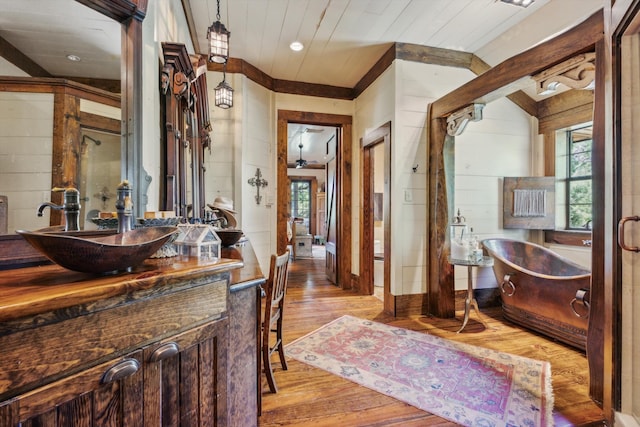 bathroom featuring a bathtub, ceiling fan, vanity, and hardwood / wood-style floors