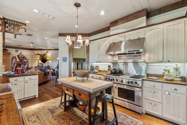 kitchen with an inviting chandelier, butcher block counters, hardwood / wood-style floors, double oven range, and pendant lighting