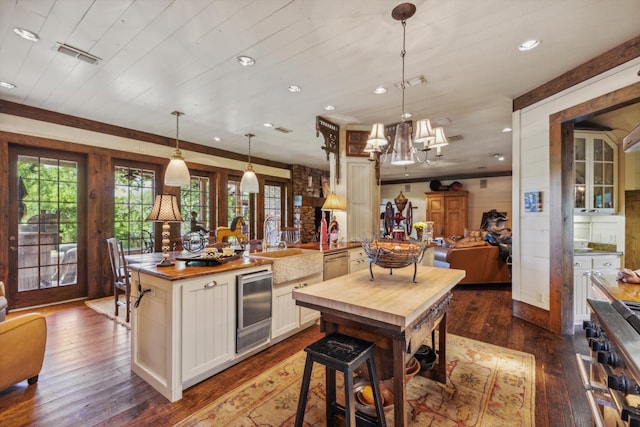 kitchen featuring decorative light fixtures, sink, an inviting chandelier, and hardwood / wood-style floors