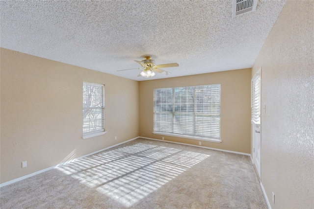 unfurnished room with light carpet, ceiling fan, a healthy amount of sunlight, and a textured ceiling