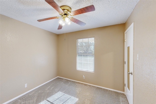 carpeted empty room with ceiling fan and a textured ceiling