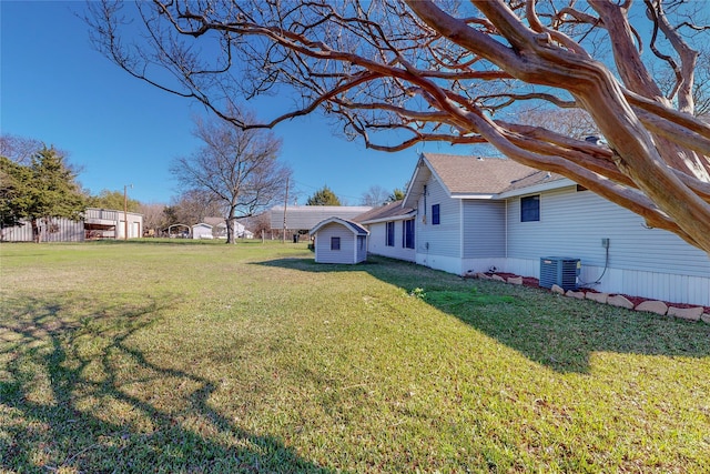 view of yard featuring central AC unit and a shed