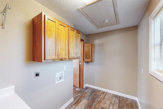 clothes washing area featuring washer hookup, hookup for an electric dryer, dark wood-type flooring, and a healthy amount of sunlight