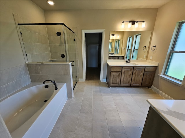 bathroom featuring independent shower and bath, vanity, and tile patterned floors