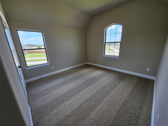 carpeted spare room featuring lofted ceiling