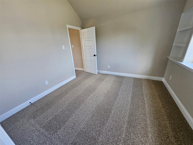 empty room with lofted ceiling and carpet floors