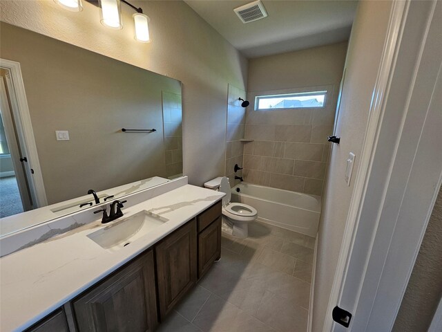 full bathroom with vanity, tiled shower / bath combo, toilet, and tile patterned floors