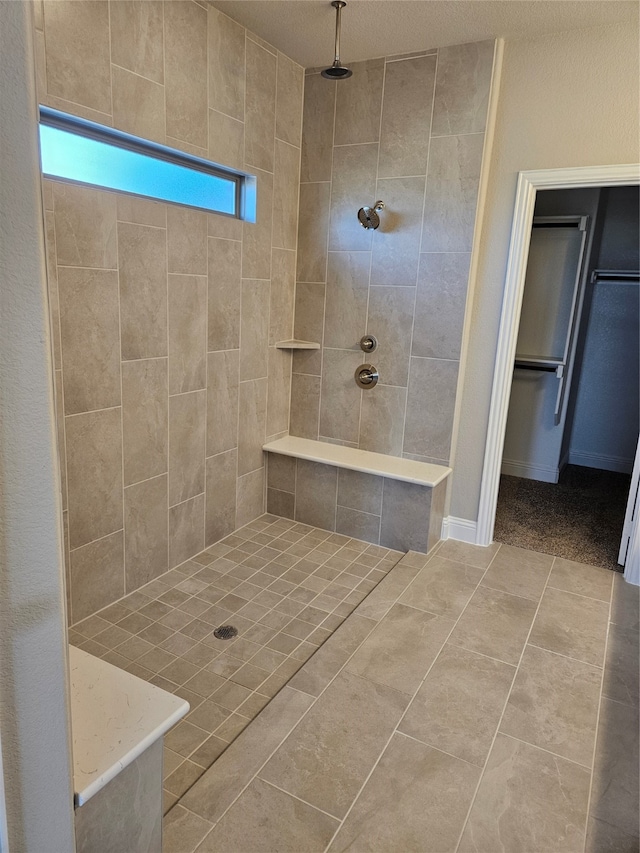 bathroom featuring a tile shower and tile patterned flooring