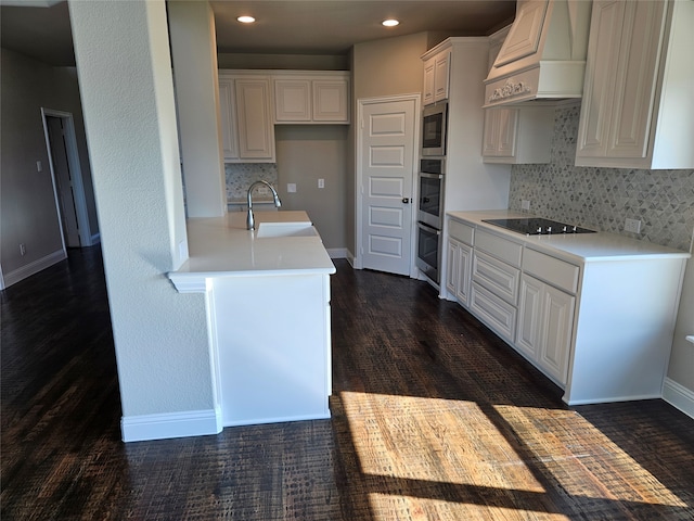 kitchen with custom range hood, white cabinetry, sink, dark wood-type flooring, and black electric stovetop