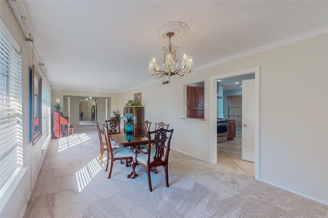 dining room with ornamental molding, light colored carpet, and plenty of natural light