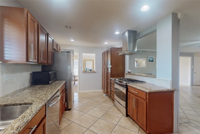 kitchen featuring light stone countertops, wall chimney exhaust hood, appliances with stainless steel finishes, and light tile patterned floors