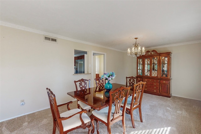 carpeted dining room with crown molding and a chandelier