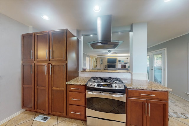 kitchen with island range hood, stainless steel range, kitchen peninsula, light stone counters, and ceiling fan