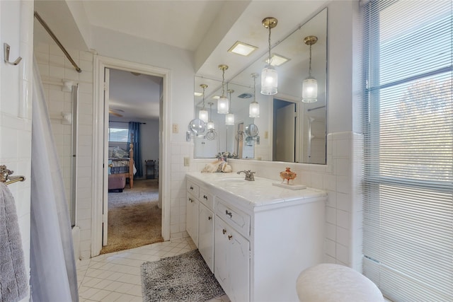 bathroom featuring vanity, plenty of natural light, tile walls, and tile patterned flooring