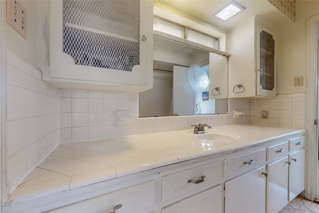 bathroom featuring vanity and backsplash