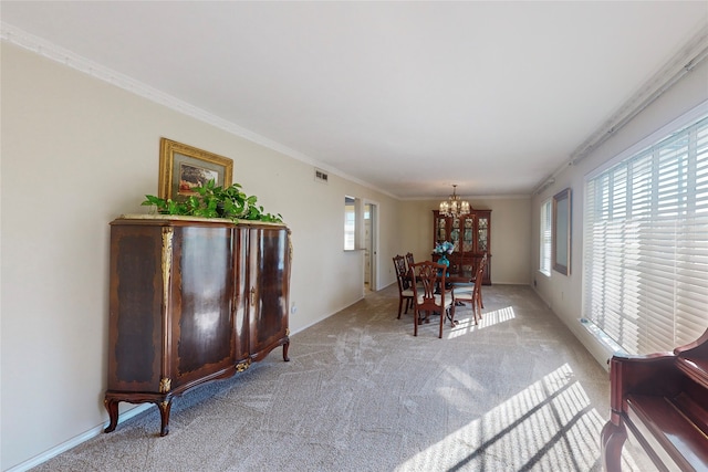 dining room featuring ornamental molding, light colored carpet, and an inviting chandelier