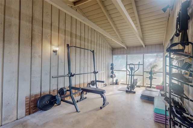 exercise room with concrete floors and high vaulted ceiling