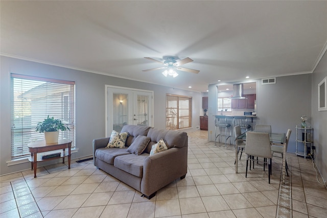 living room featuring ornamental molding, light tile patterned floors, and ceiling fan