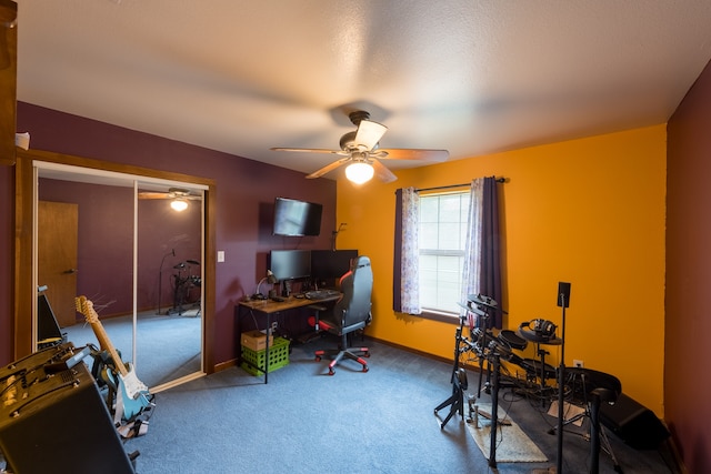 home office with carpet flooring, ceiling fan, and a textured ceiling