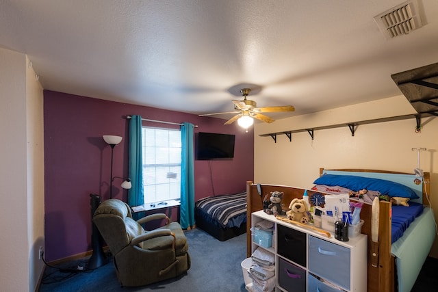 carpeted bedroom with a textured ceiling and ceiling fan