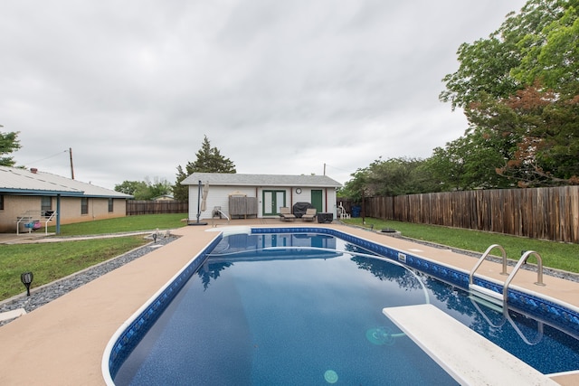 view of pool with a yard, a patio, and a diving board