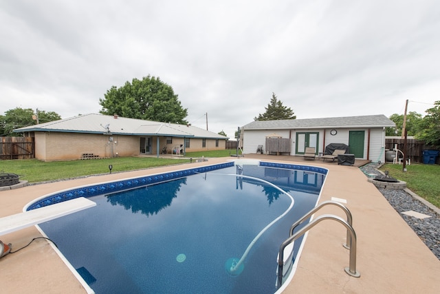 view of pool featuring a yard, a diving board, and a patio