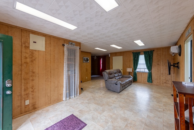 living room with wood walls, a wall unit AC, and electric panel