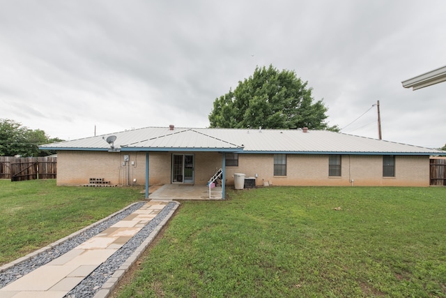 back of property featuring a yard and a patio