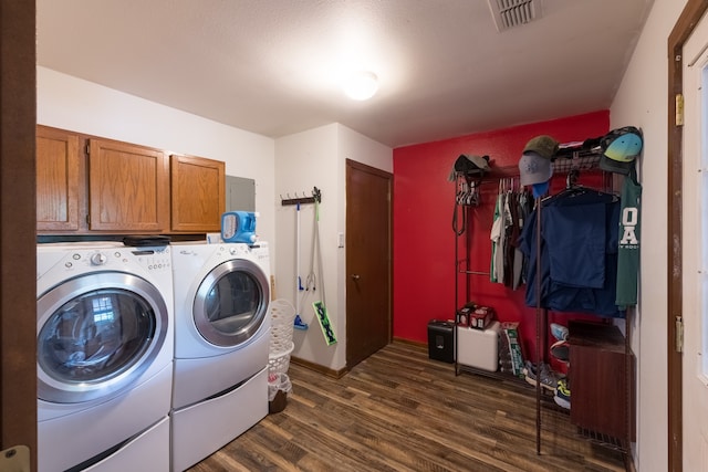 laundry room with washer and dryer, cabinets, and dark hardwood / wood-style flooring