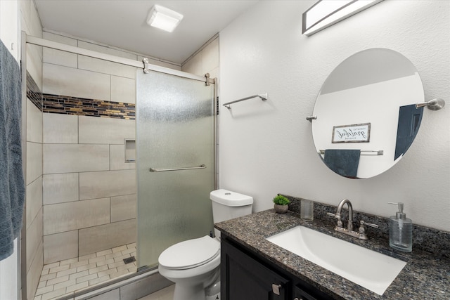 bathroom with a shower with shower door, toilet, and oversized vanity