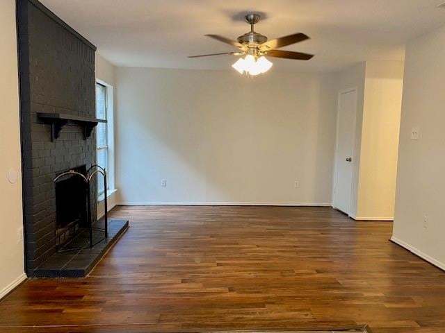 unfurnished living room featuring ceiling fan, a fireplace, and dark hardwood / wood-style flooring