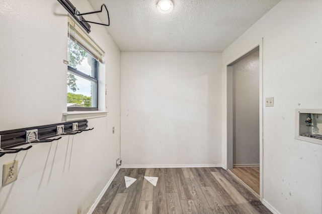 interior space with hardwood / wood-style floors, washer hookup, and a textured ceiling