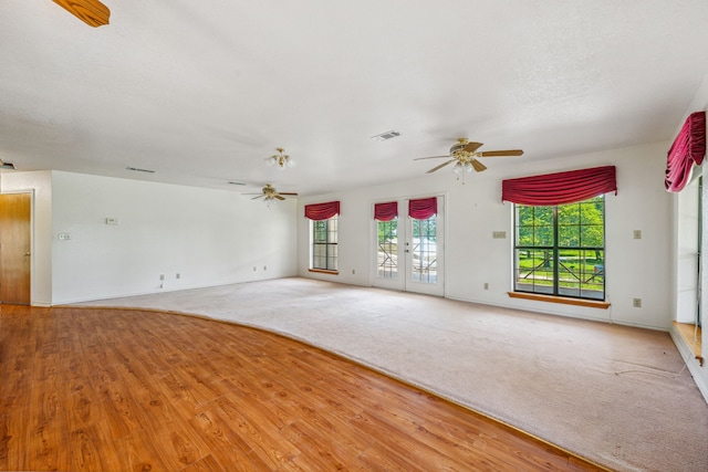 unfurnished room featuring french doors, a healthy amount of sunlight, light hardwood / wood-style floors, and ceiling fan