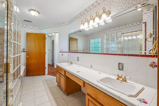 bathroom featuring tasteful backsplash, double vanity, tile flooring, and tile walls