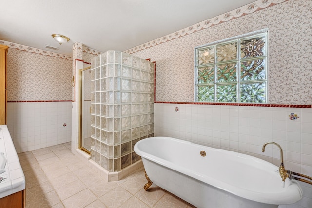 bathroom with tile walls, plus walk in shower, and tile flooring