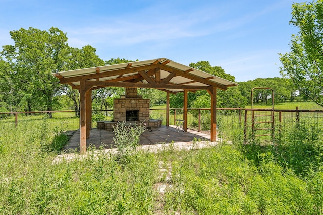 view of yard with a patio area, an outdoor stone fireplace, and a gazebo