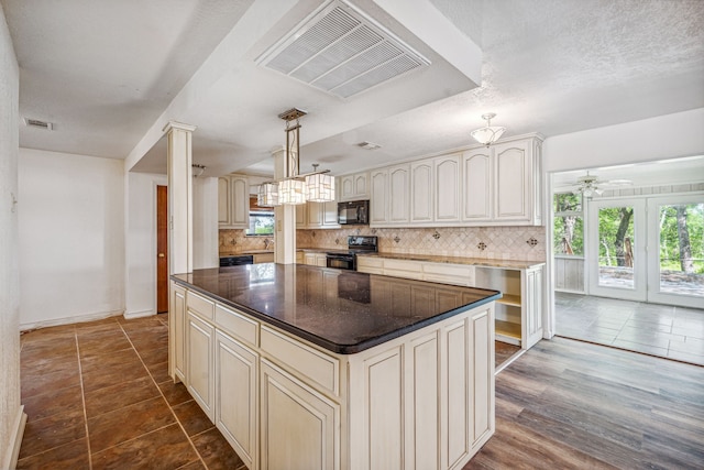 kitchen featuring decorative light fixtures, black appliances, hardwood / wood-style floors, backsplash, and a kitchen island