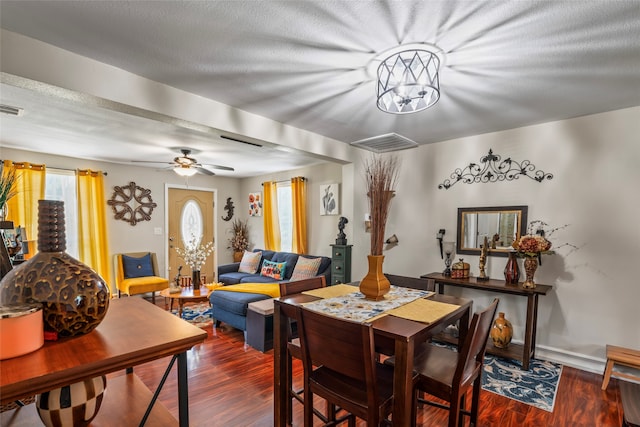 dining room featuring dark wood-type flooring, a textured ceiling, and ceiling fan