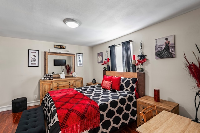 bedroom featuring a textured ceiling and dark hardwood / wood-style flooring