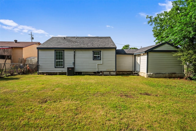 rear view of property with central AC and a yard