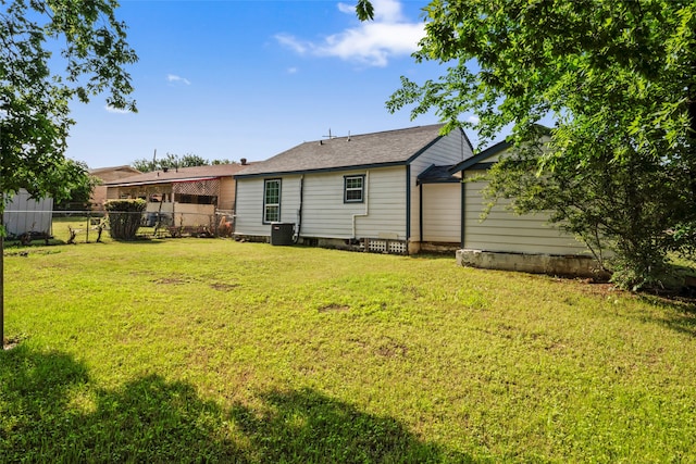 back of property with a lawn and central AC unit